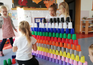 dziewczynki konstruują wieżę z kubeczków